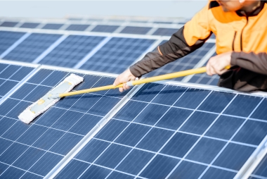 Técnico realizando mantenimiento y limpieza de paneles fotovoltaicos con cepillo; placas solares para autoconsumo en Vitoria-Gasteiz, Álava, País Vasco