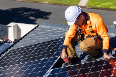 Técnico con casco reparando y ajustando paneles solares en tejado; servicio técnico y mantenimiento de placas solares en Vitoria-Gasteiz, Álava, País Vasco